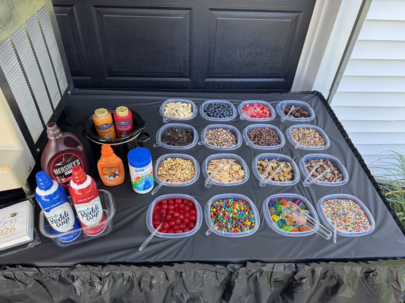 Close-up of a topping bar with candy, fruit, and dessert toppings in bowls