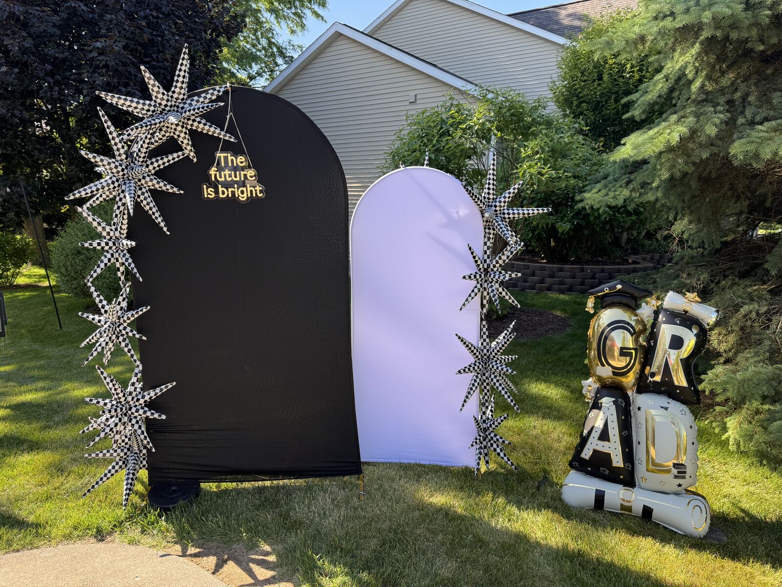 Photo backdrop and picture arch setup with a neon sign and graduation balloons for a photo opportunity