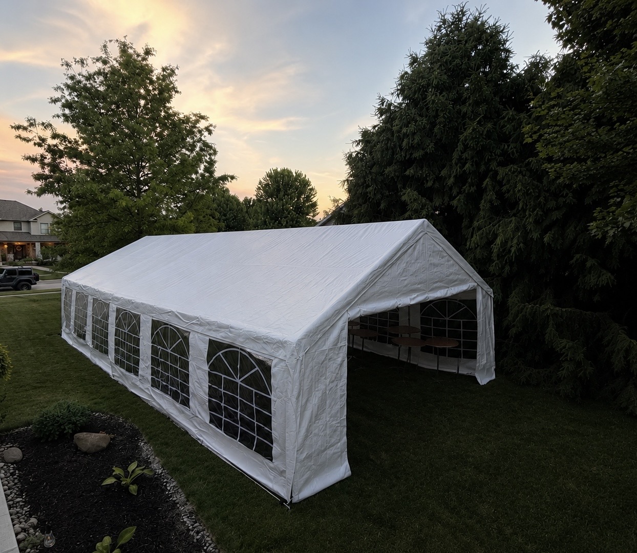 Premium white frame tent installed in a backyard at dusk